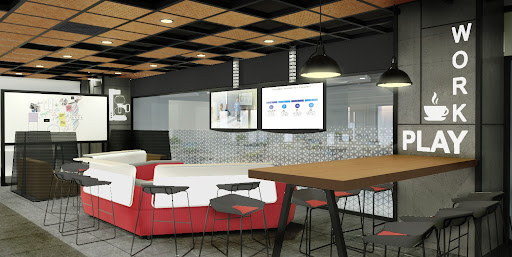Office breakout area with red seating and a high table